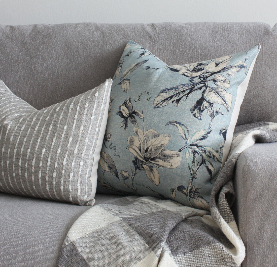 Blue floral and gray stripe pillow cover on sofa