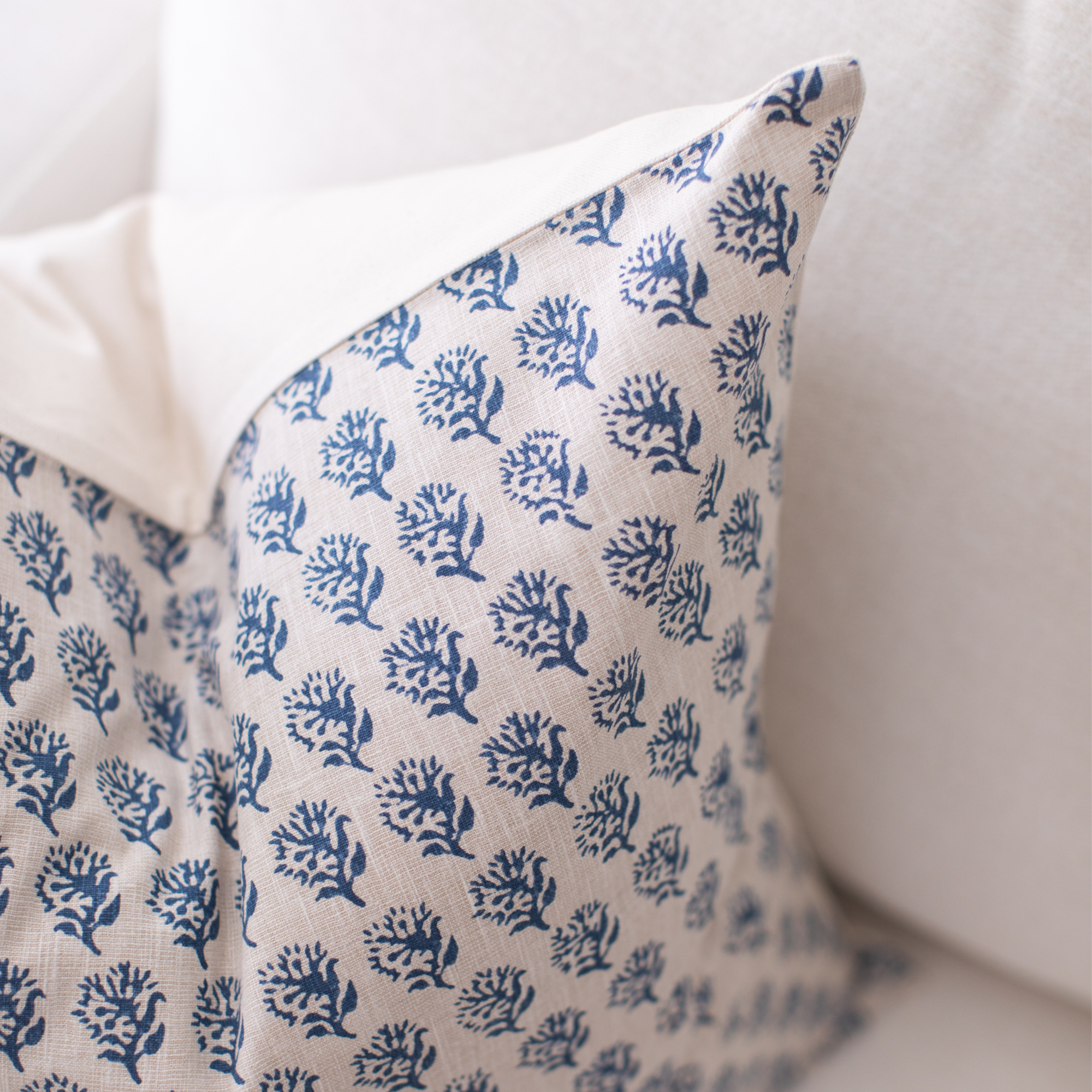 Decorative pillow with blue floral pattern on a neutral background