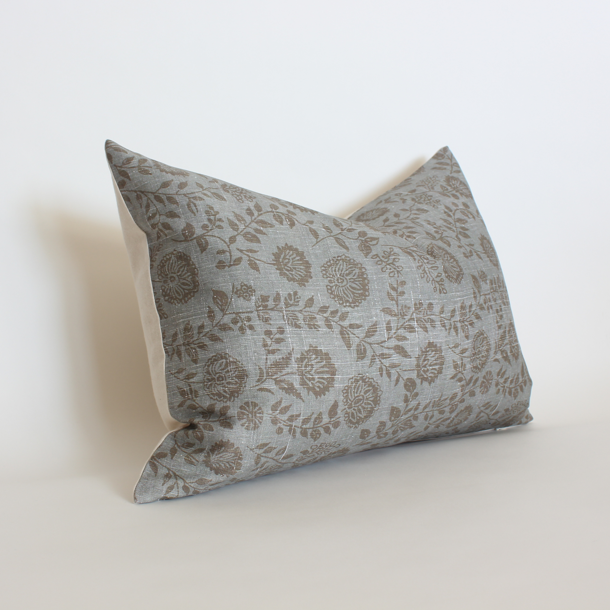 Angled view of blue gray botanical lumbar throw pillow cover, neutral coastal accent pillow