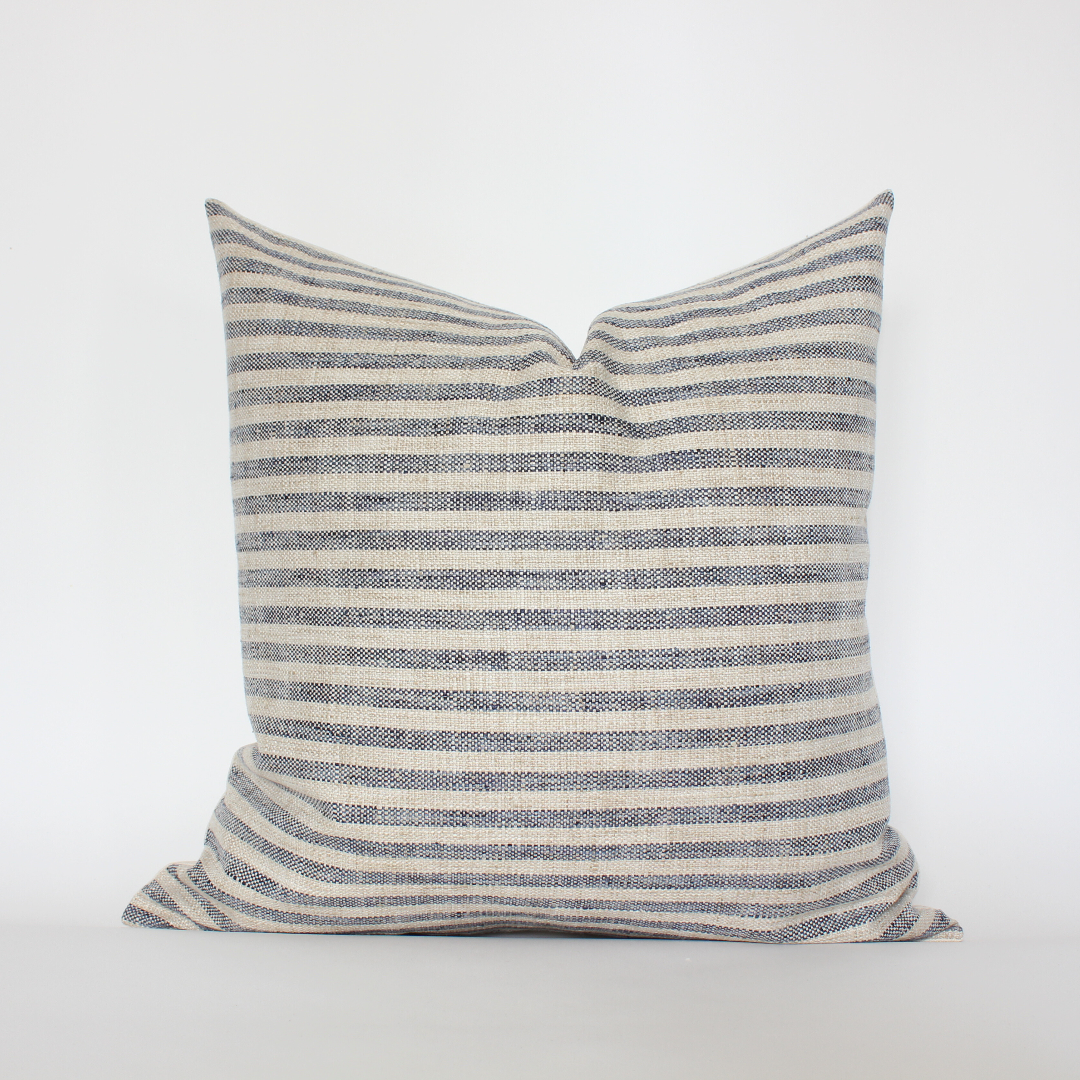 Striped pillow with blue and beige pattern on a white background
