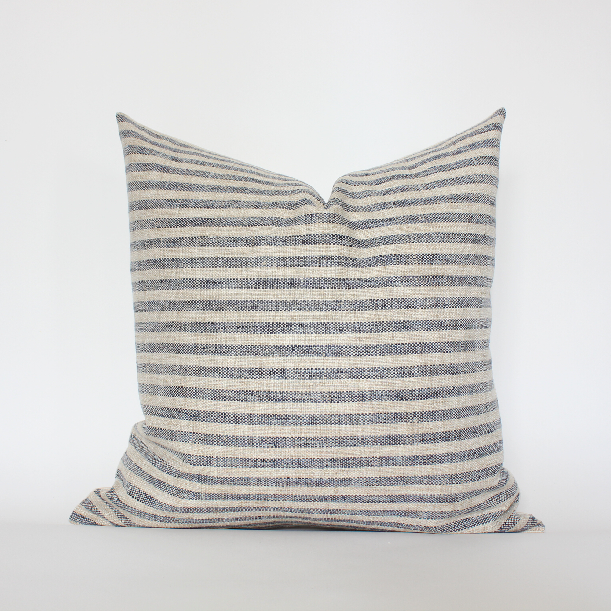 Striped pillow with blue and beige pattern on a white background