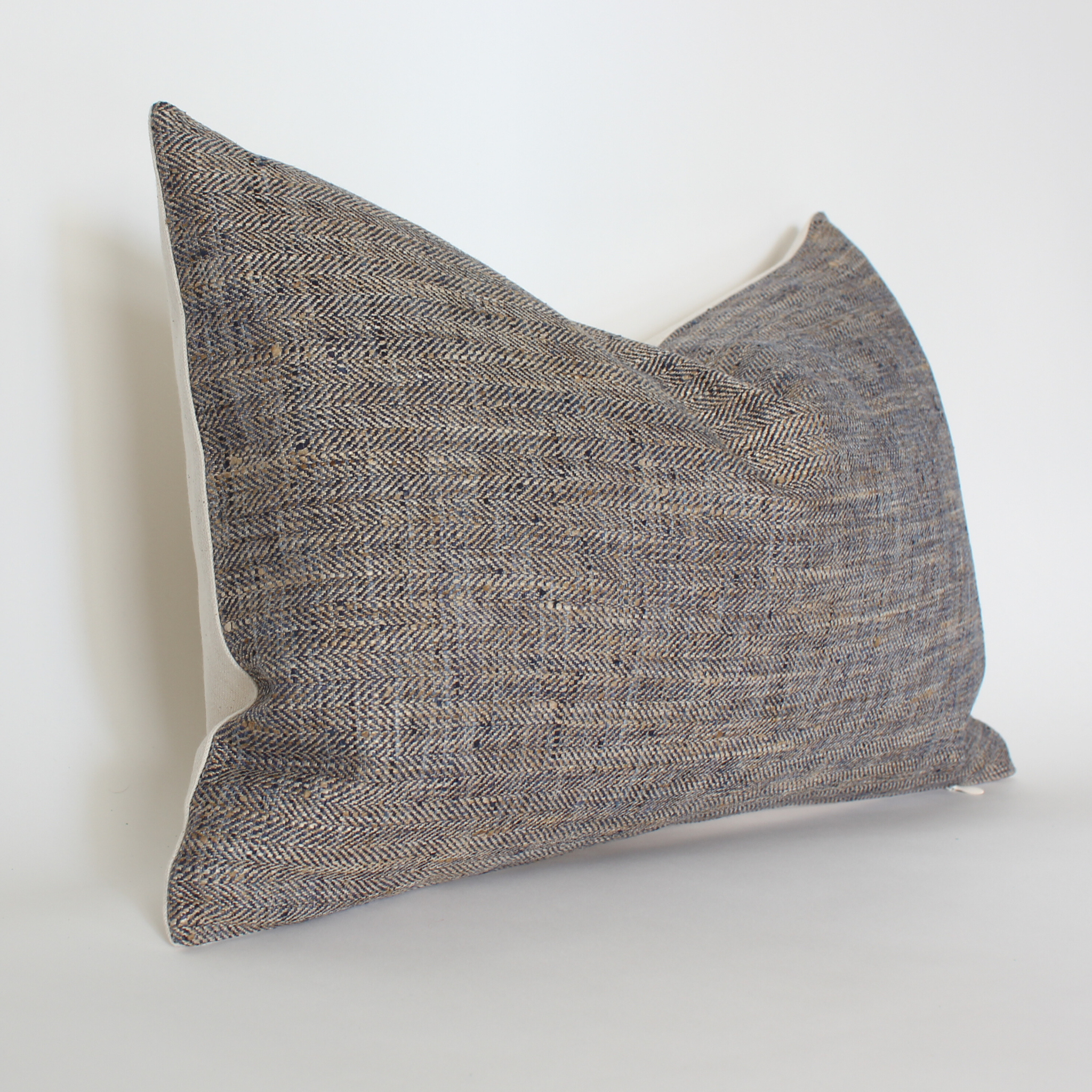 Brown herringbone tweed lumbar pillow cover, angled view showing cream fabric back