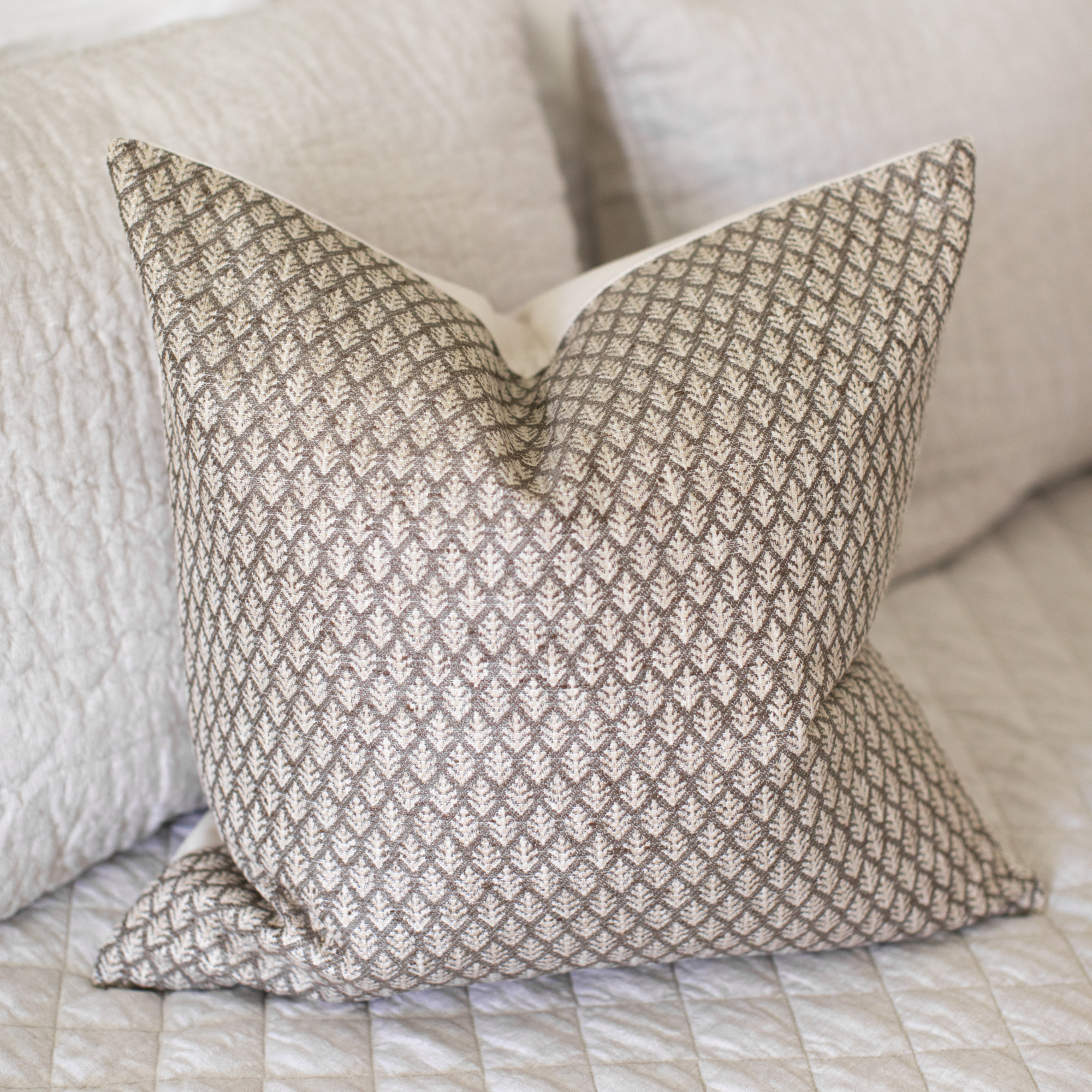 brown woven pillow with leaf motif