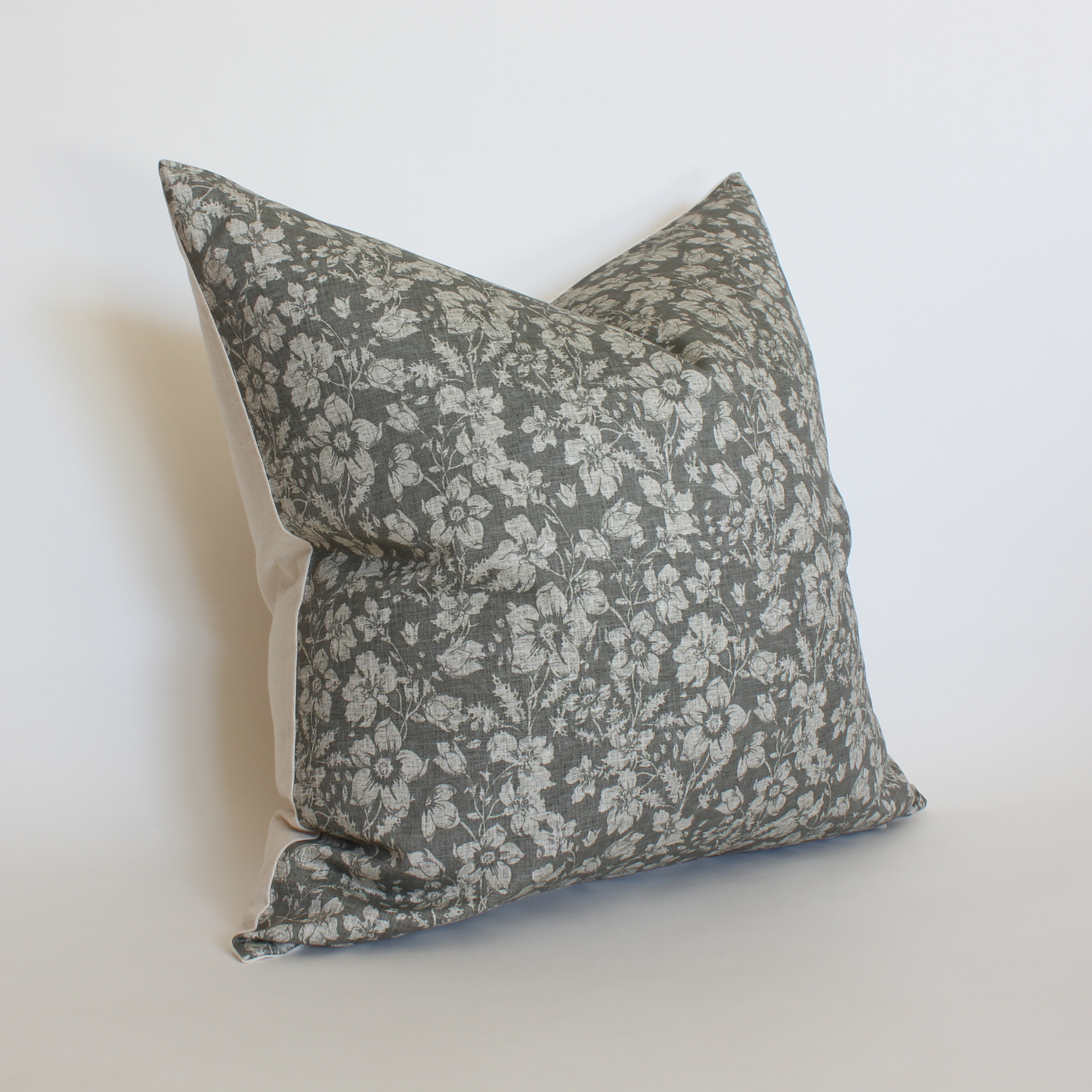 Close up of charcoal botanical pillow cover with cream scattered floral print, neutral home decor
