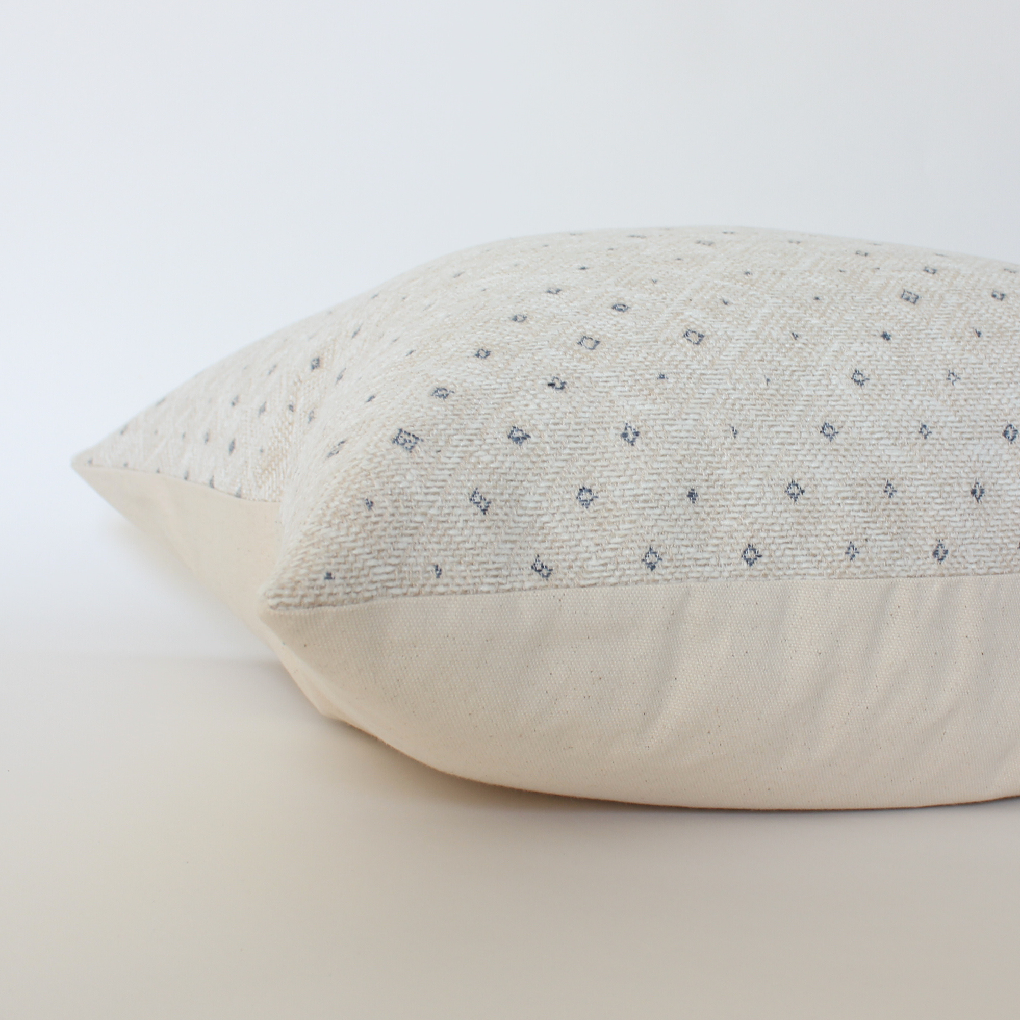 Textured pillow with subtle dotted pattern on a light background
