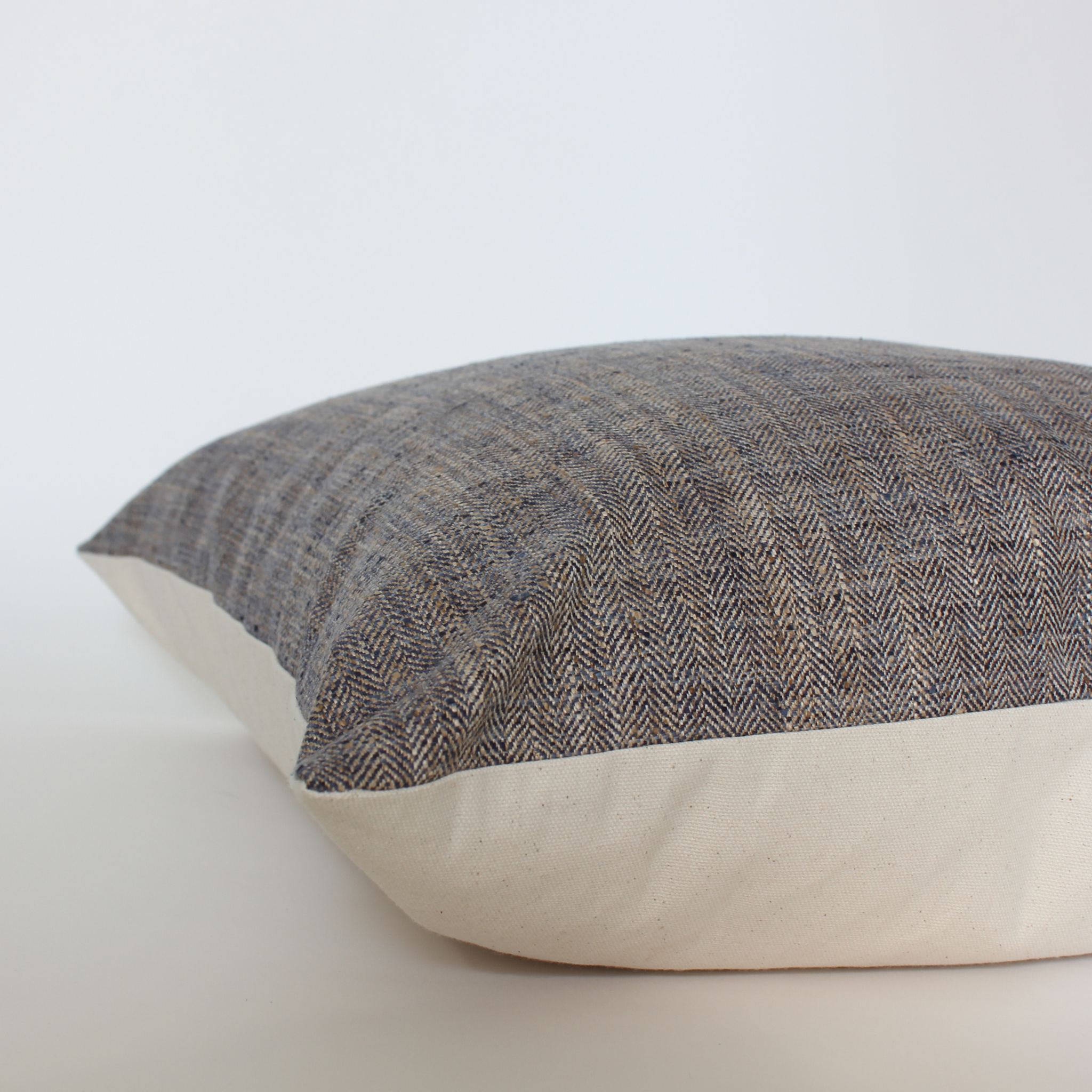 Brown herringbone tweed lumbar pillow cover, side view showing cream fabric backing