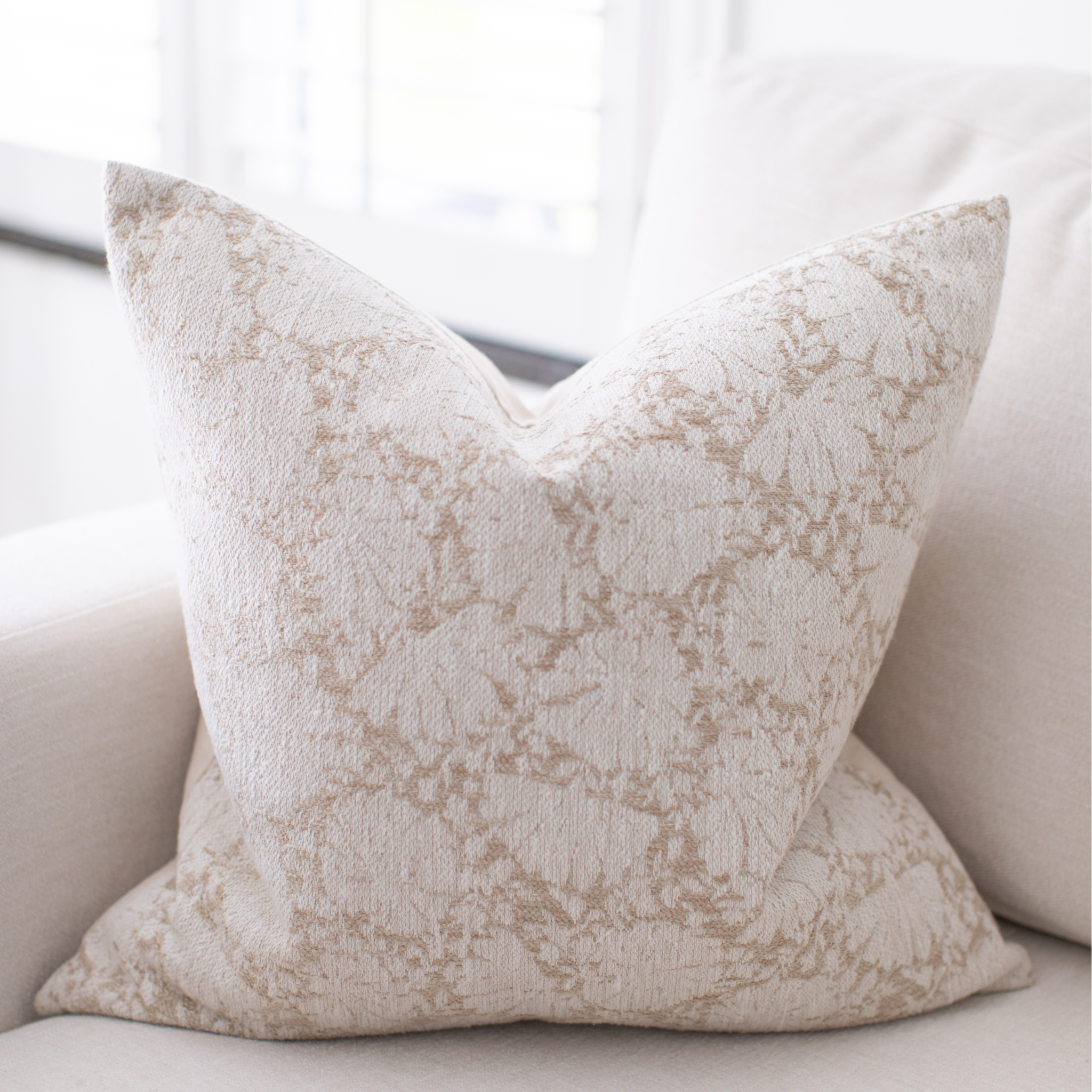 Textured ivory pillow on a light-colored sofa
