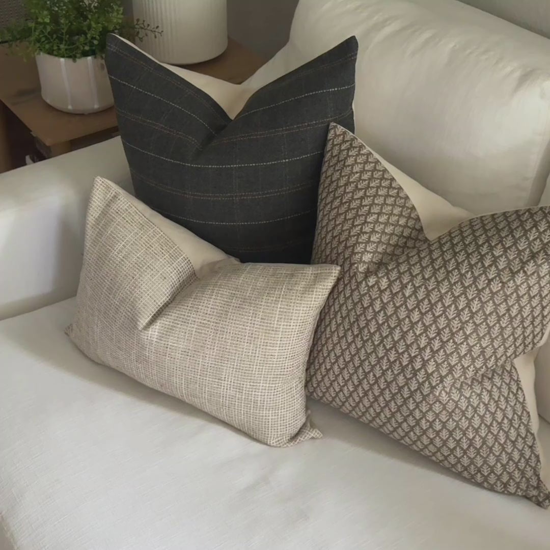 video of neutral pillow set of 3 on a sofa