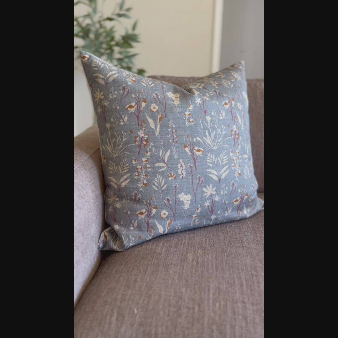 Slate blue wildflower pillow cover styled on gray sofa, transitional living room decor