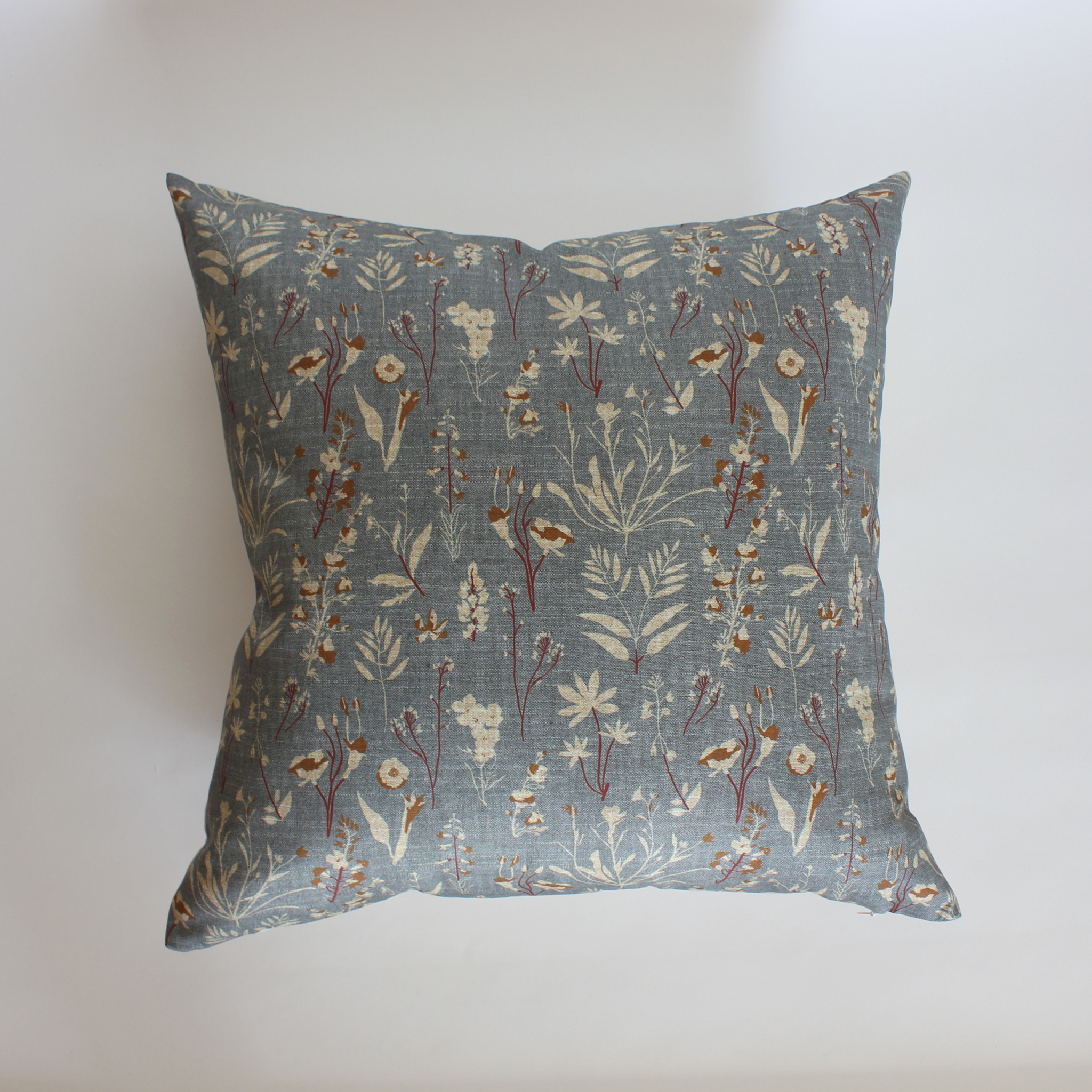 Square slate blue pillow cover with scattered wildflower botanical print, coastal home decor