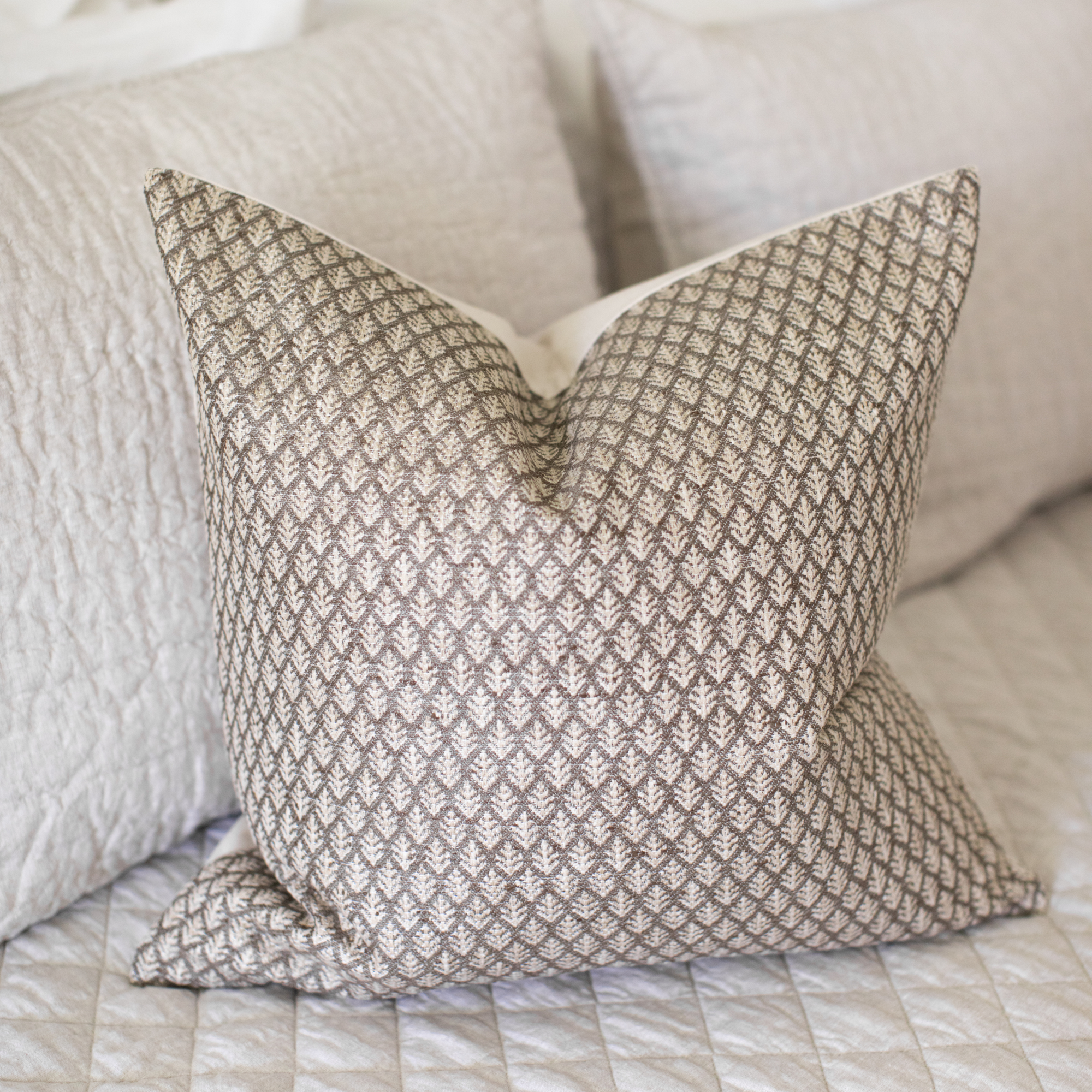 Textured pillow on a sofa with a neutral color scheme
