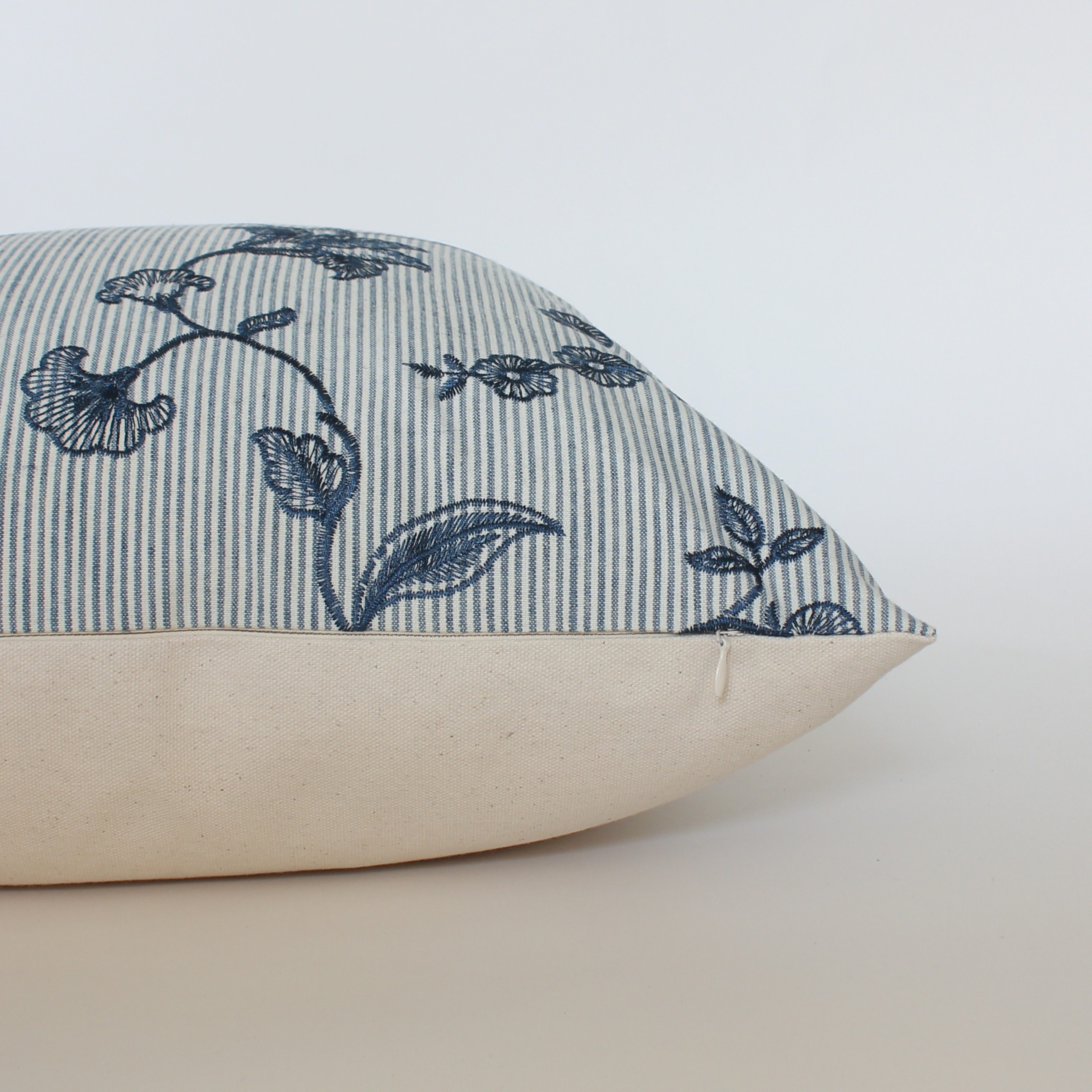 Decorative pillow with blue floral pattern on a white background