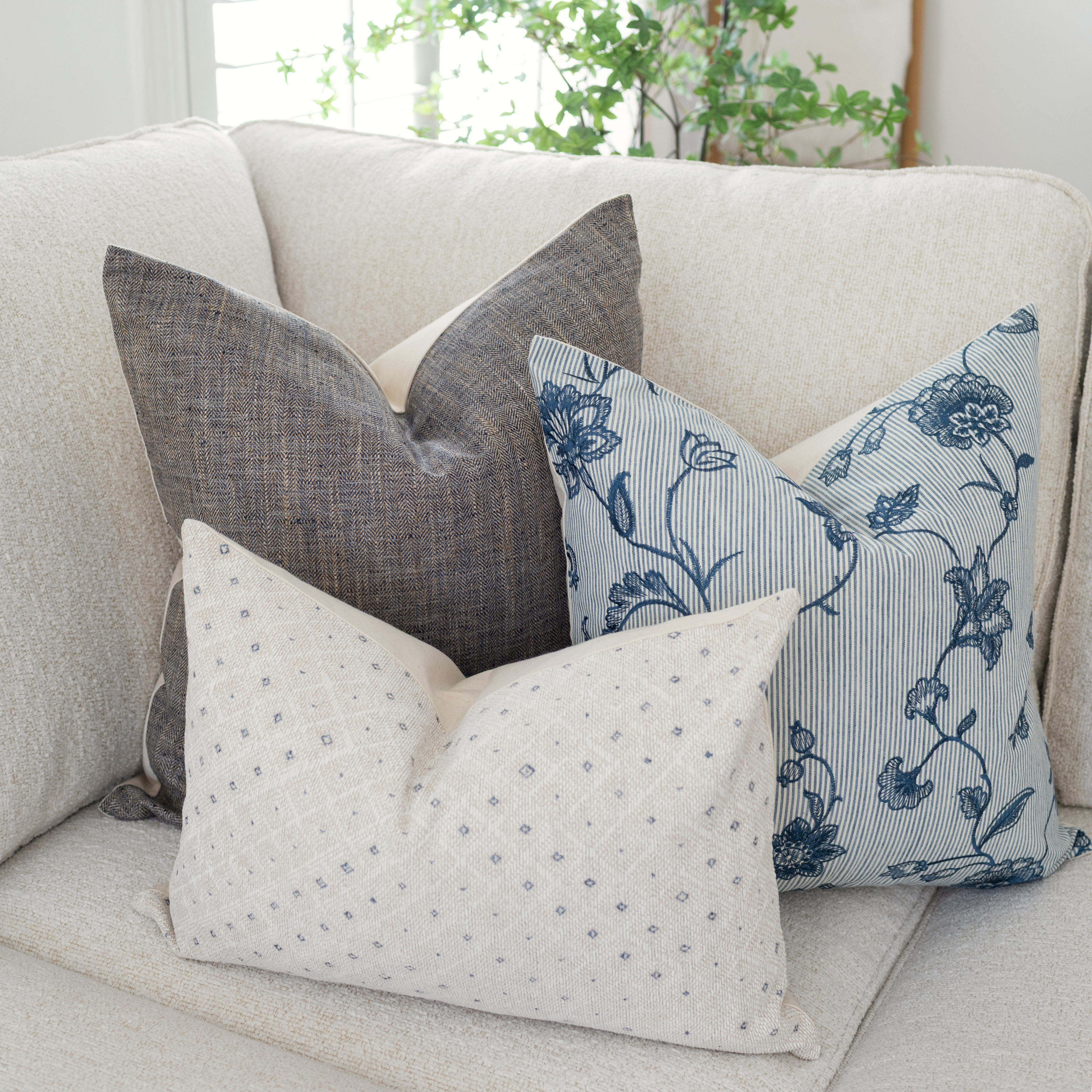Decorative pillows on a beige sofa with a neutral background